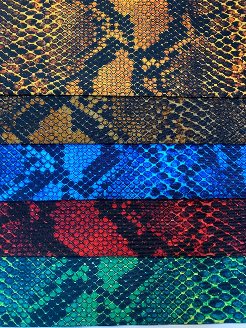 May include: Five fabric swatches with a snake skin pattern. The swatches are in the colours brown, blue, red, green, and black.