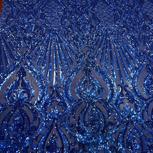 Puede incluir: Tela azul real con lentejuelas con un patr&oacute;n de damasco. Las lentejuelas est&aacute;n dispuestas en un patr&oacute;n repetitivo de espirales y hojas.