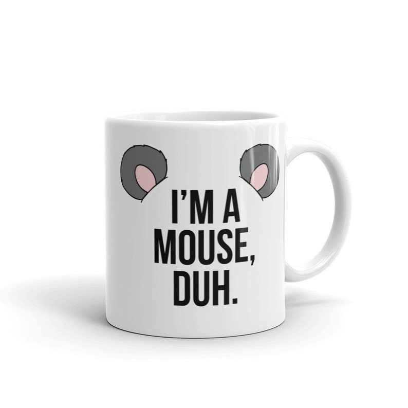 May include: White ceramic coffee mug with a black and white graphic of mouse ears and the text "I'm a mouse, duh."