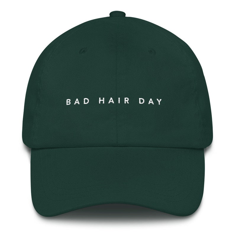 May include: A dark green baseball cap with the text "BAD HAIR DAY" embroidered in white on the front.