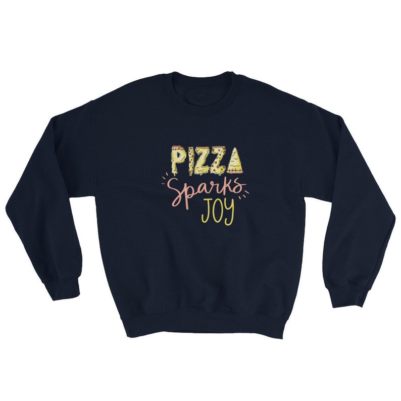 May include: Navy blue sweatshirt with the text "Pizza Sparks Joy" in yellow and pink lettering. The word "Pizza" is made up of pizza slices.