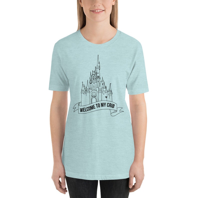 May include: A light blue t-shirt with a black outline of a castle and the text "WELCOME TO MY CRIB" on a banner.