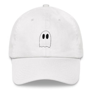 Op de afbeelding: Witte baseballpet met een zwart geborduurd spookontwerp. Het spook heeft twee zwarte ogen.