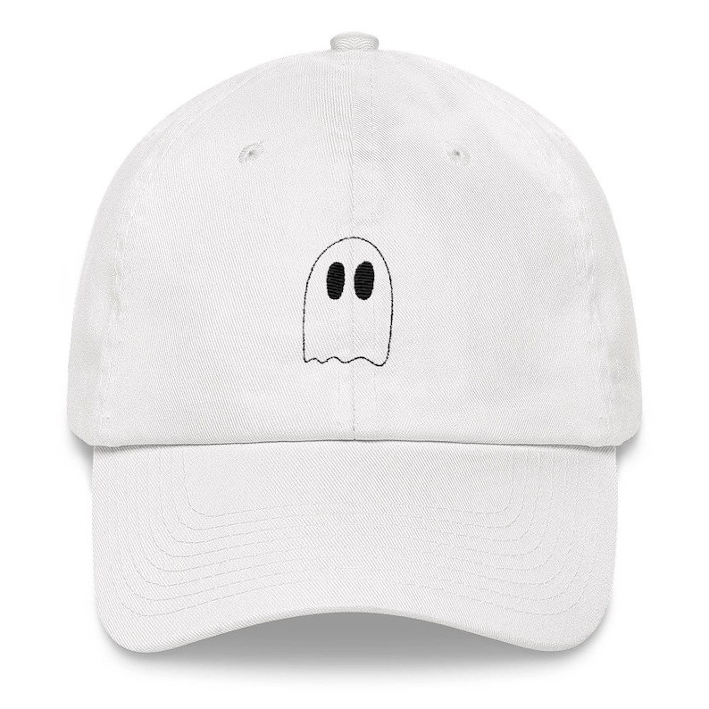 Op de afbeelding: Witte baseballpet met een zwart geborduurd spookontwerp. Het spook heeft twee zwarte ogen.