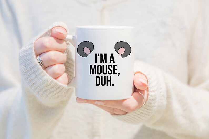 May include: White ceramic mug with black text that reads "I'm a mouse, duh."  The mug has two gray mouse ears with pink insides.