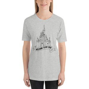 May include: A heather grey t-shirt with a black outline of a castle and the text "Welcome to my crib" on a banner.