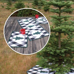 Puede incluir: Una falda de &aacute;rbol acolchada en blanco y negro con &aacute;rboles de pino verdes, un camino de mesa y dos manteles individuales. El texto "Buffalo Lodge" y "Tree Skirt, Table Runner & Placemats" est&aacute; en la parte superior de la imagen. El texto "Krista Moser" y "The Quilted Life" est&aacute; en la parte inferior de la imagen.