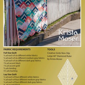 K&ouml;nnte beinhalten: Ein Quiltmuster mit einem Chevron-Design in Wei&szlig;-, Grau-, Rosa- und Blaut&ouml;nen. Der Quilt ist &uuml;ber einen wei&szlig;en Lattenzaun gelegt. Das Muster hei&szlig;t "City Girl Chevron" und wurde von Krista Moser entworfen. Das Bild enth&auml;lt den Text "City Girl Chevron", "Krista Moser", "The Quilted Life", "Creative Grids Non-Slip", "Large 60&deg; Diamond Ruler", "by Krista Moser", "Item 10004 City Girl Chevron", "&copy;2020 The Quilted Life", "kristamoser.com", "krista_moser #citygirlchevronquilt" und einen Barcode.