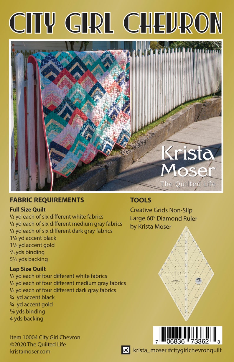 K&ouml;nnte beinhalten: Ein Quiltmuster mit einem Chevron-Design in Wei&szlig;-, Grau-, Rosa- und Blaut&ouml;nen. Der Quilt ist &uuml;ber einen wei&szlig;en Lattenzaun gelegt. Das Muster hei&szlig;t "City Girl Chevron" und wurde von Krista Moser entworfen. Das Bild enth&auml;lt den Text "City Girl Chevron", "Krista Moser", "The Quilted Life", "Creative Grids Non-Slip", "Large 60&deg; Diamond Ruler", "by Krista Moser", "Item 10004 City Girl Chevron", "&copy;2020 The Quilted Life", "kristamoser.com", "krista_moser #citygirlchevronquilt" und einen Barcode.