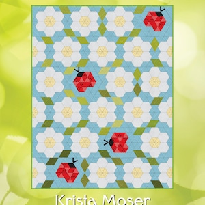 Op de afbeelding: Een quiltpatroon met een herhalend ontwerp van witte bloemen en groene bladeren op een lichtblauwe achtergrond. Vier rode lieveheersbeestjes zijn verspreid over het patroon. De quilt is getiteld "Ladybug Bloom" en is van Krista Moser, The Quilted Life. De afgewerkte maat is 54" x 71".