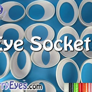 May include: White plastic eye sockets for craft projects. The sockets are arranged in a grid pattern on a blue surface. The text "Eye Sockets" is in the center of the image. The text "FurryEyes.com" is in the bottom left corner of the image. A variety of colored threads are in the bottom right corner of the image.