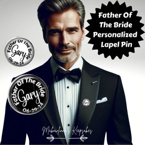 May include: A black and white lapel pin with the text "Father Of The Bride Gary 06-29-24" on a silver background. The pin is worn by a man in a black tuxedo.