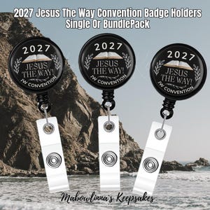 Puede incluir: Tres portatarjetas retráctiles circulares negros con el texto 2027 JESUS THE WAY! JW CONVENTION y una ilustración de un libro abierto. Cada soporte tiene una correa de plástico blanco con un botón de presión metálico para tarjetas de identificación.
