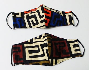 May include: Two fabric face masks with geometric patterns. The top mask has a black, white, red, and blue pattern. The bottom mask has a black, white, brown, and beige pattern.
