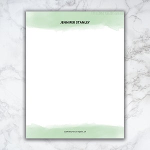 Könnte beinhalten: Eine weiße Briefkopfvorlage mit einem hellgrünen Aquarelldesign oben und unten. Der Text "JENNIFER STANLEY" ist oben auf der Seite zentriert. Die Adresse "12345 Etsy Rd Los Angeles, CA" ist unten auf der Seite zentriert.