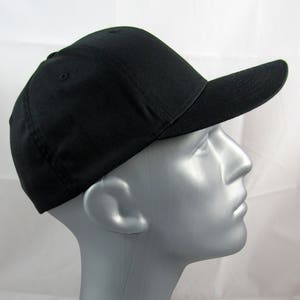 May include: A black baseball cap with a curved brim. The cap is made of a soft, cotton fabric.