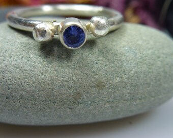 Belle tanzanite bleue dans une monture en argent, bague en argent faite à la main à partir de matériaux du commerce équitable. La surface de la bague est mate