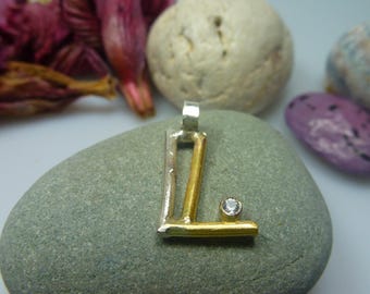 The letters pendant made of FAIRTRADE silver and FAIRTRADE solid gold.
