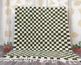 May include: A green and white checkered rug with fringe. The rug is made of wool and has a traditional Moroccan design.