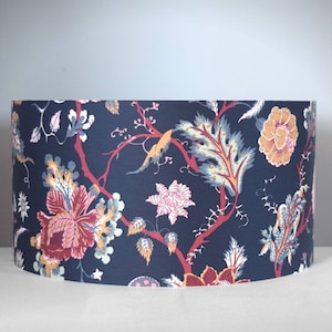 May include: A drum lampshade with a dark blue floral pattern. The design includes red branches, and flowers in shades of pink, orange, and yellow. The lampshade is suitable for a table or floor lamp, and is approximately 30 cm in diameter.