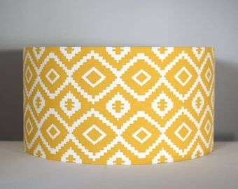 May include: A yellow lampshade with a white geometric pattern. The pattern is a repeating diamond shape.