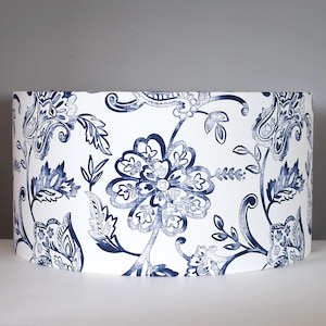 May include: White lampshade with a blue floral pattern. The pattern features paisley and floral designs.