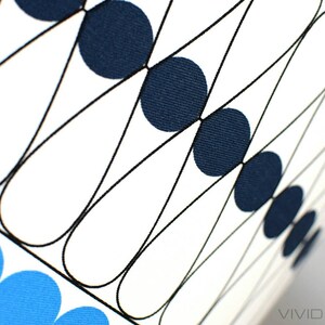 May include: A white fabric with a geometric pattern of black lines and blue and navy blue circles. The fabric is textured and has a subtle sheen.