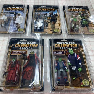 May include: Five Star Wars Celebration Cosplay action figures in clear plastic blister packaging. The figures include Hoth Trooper, Scarif Trooper, Zuvio, Bounty Hunter, and C.O.P. Officer, each displayed on a card with character artwork and branding.