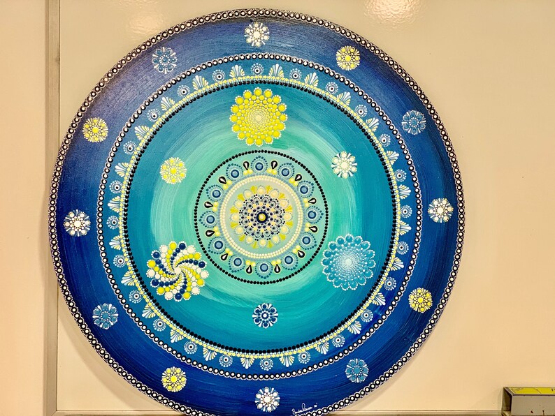 Dot mandala painting, meticulously hand-crafted with intricate details using the technique of pointillism. The colors of the mandala bring a sense of peace and tranquility to any space it adorns. This is a unique pice made by Sandra Ramos
