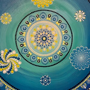 May include: A blue and green mandala with yellow and white dots. The mandala is made up of concentric circles with different patterns. The background is a gradient of blue and green.