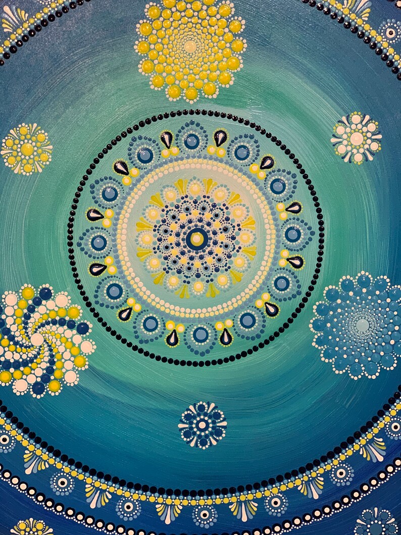 May include: A blue and green mandala with yellow and white dots. The mandala is made up of concentric circles with different patterns. The background is a gradient of blue and green.