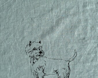 May include: A black and white line drawing of a West Highland White Terrier dog on a light blue linen tea towel.