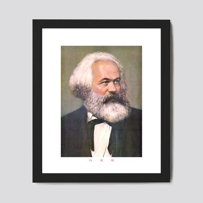 May include: A framed portrait of Karl Marx, a German philosopher, economist, historian, sociologist, political theorist, journalist and revolutionary socialist. The portrait is in color and shows Marx with a white beard and mustache, wearing a dark suit and a white shirt with a black bow tie. The portrait is framed in black and has a white mat.