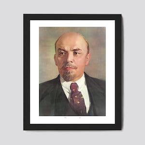 Op de afbeelding: Een zwart-wit portret van een man met een snor en sikje, die een donker pak en een rode stropdas met een wit overhemd draagt.