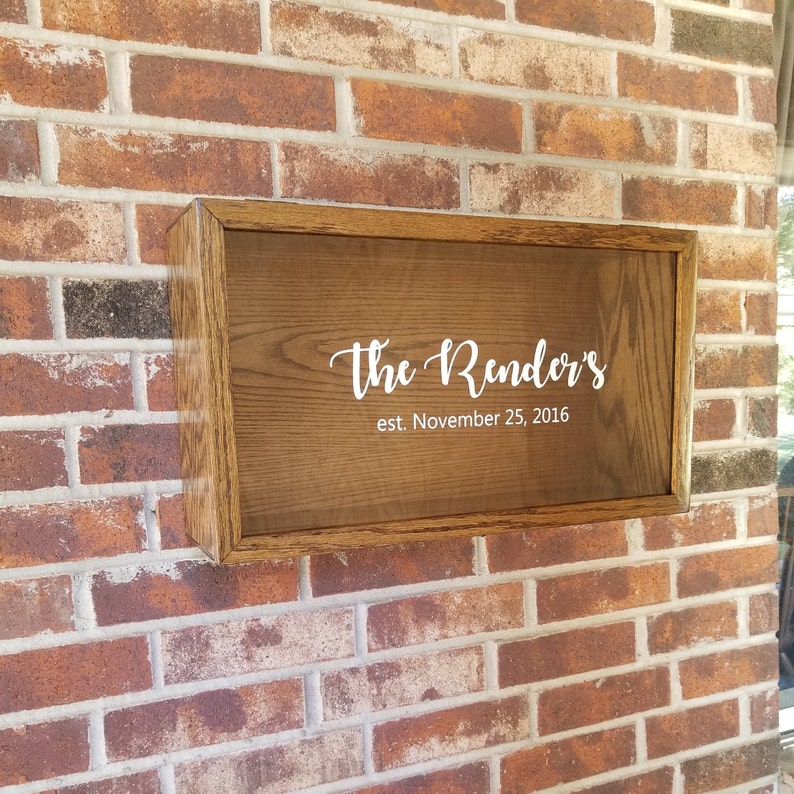 May include: A wooden sign with a brown stain and a white frame. The sign says "The Render's est. November 25, 2016".