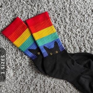 レインボーソックスを履いた猫の覗き見 | ブラックフット昇華ソックス | LGBTQソックス | ゲイプライドソックス | プライド月間ソックス | おもしろい黒猫ソックス