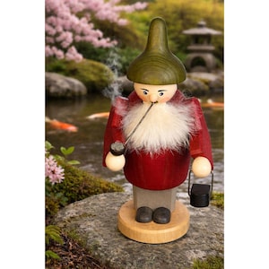 May include: A wooden gnome figurine with a red coat, green hat, and white beard, smoking a pipe. The gnome is holding a small black bucket. The figurine is standing on a wooden base, with a serene outdoor background.
