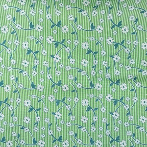 Puede incluir: Tela verde con rayas verticales blancas y un patrón repetido de flores blancas con tallos y hojas turquesas. El diseño floral crea una estética fluida y orgánica. Adecuado para diversos proyectos de costura y artesanía.