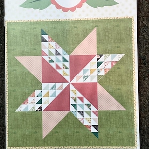 May include: A rectangular paper pattern cover titled #156 Sugar Cookie by Lella Boutique. The cover features a central eight-pointed star quilt block design composed of green, pink, and multi-coloured floral patterned fabric segments.