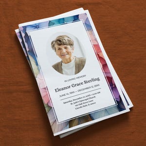 Könnte beinhalten: Mehrere Gedenkprogramme mit einem floralen Design in Blau-, Rosa- und Lilatönen. Das Programm zeigt ein Porträt einer Frau und den Text "Eleanor Grace Sterling". Der untere Teil des Programms lautet: "Bearbeitbare Gedenk- und Beerdigungsvorlagen, die ein in Farbe gelebtes Leben ehren."