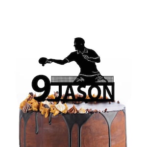 Puede incluir: Topper de pastel en silueta negra de un jugador de tenis de mesa con una pala, una mesa de tenis de mesa, el número 9 y el nombre "JASON".