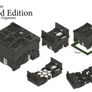 May include: A black plastic token organiser with the text "BATOH 2nd Edition Token Organiser" on the top. The organiser is made up of multiple interlocking pieces and is designed to hold small tokens or game pieces. The organiser is 76 mm wide and 76 mm long, and is smaller than a standard game board.