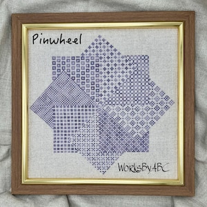 Pode incluir: Um desenho de ponto cruz emoldurado de uma roda de vento em tons de roxo e branco. O desenho é intitulado "Pinwheel" e assinado "WorksByABC".