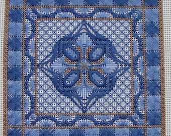 May include: A blue and brown cross-stitch embroidery pattern with a geometric design. The pattern is framed with a brown border.