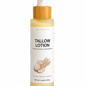 Könnte beinhalten: Eine Flasche aus Milchglas mit Wellness By Ari Talg-Lotion, weißem Pumpspender und hellbraunem Holzoptik-Kragen. Das Etikett zeigt schwarzen Text, eine braune botanische Illustration und die Angaben Net Wt. 3.35 oz / 95 g, Nourish, Protect, Restore.