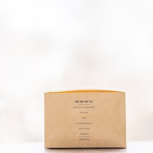 May include: A beige box with a honeycomb pattern and the text "We say no to: Synthetic fragrances, Parabens, Dyes, Petrochemicals & Phthalates, Parabens, Roman's 5.5."