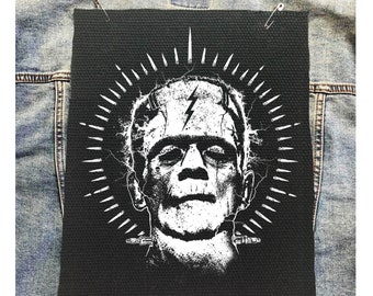 Toppa Frankenstein per la schiena: tatuaggio horror, stile punk fai-da-te