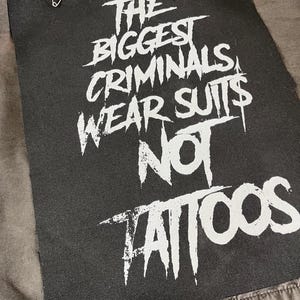 Large punk back patch with bold stencil text 'The Biggest Criminals Wear Suits Not Tattoos', perfect for jackets, vests, and anti-establishment streetwear.