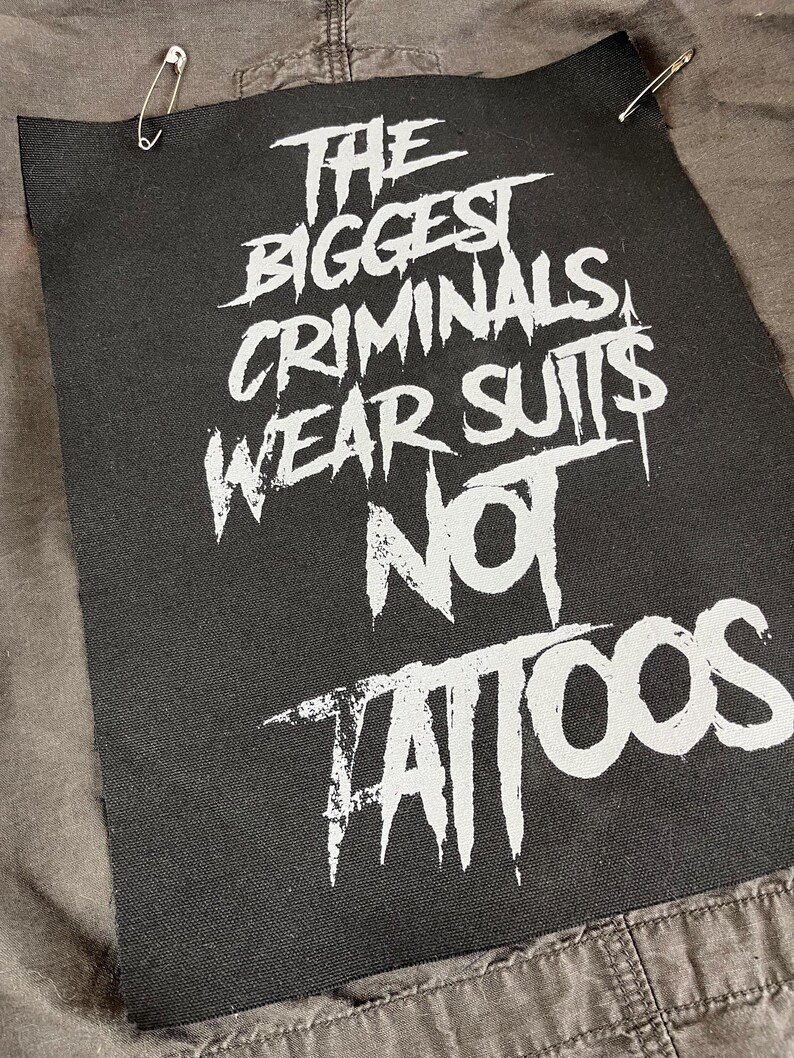 Large punk back patch with bold stencil text 'The Biggest Criminals Wear Suits Not Tattoos', perfect for jackets, vests, and anti-establishment streetwear.