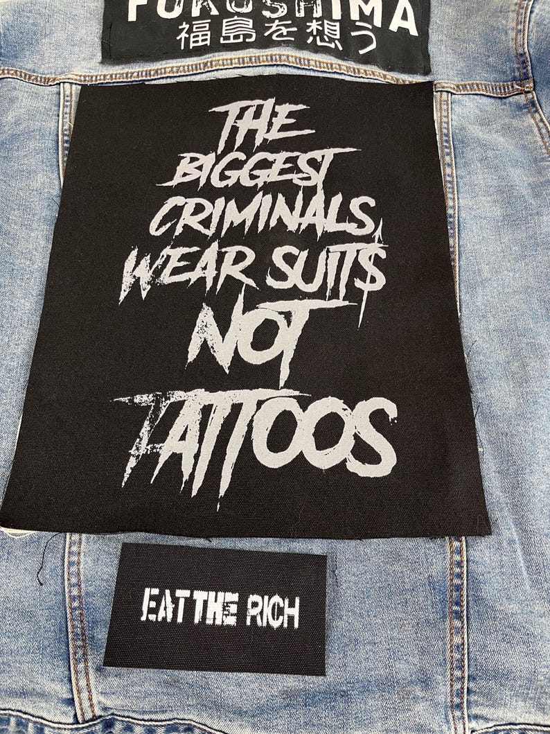 Large punk back patch with bold stencil text 'The Biggest Criminals Wear Suits Not Tattoos', perfect for jackets, vests, and anti-establishment streetwear.